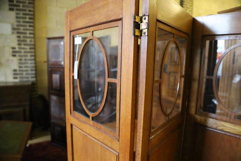 An Edwardian glazed oak four fold dressing screen, each panel 40 x 180cm